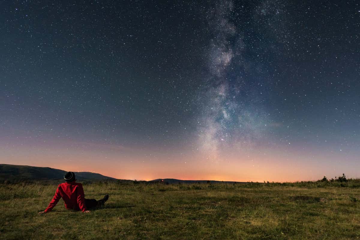 A young man lying on the grass and watching the Milky Way. Taken in A Veiga, Orense.